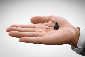 Man holding a hearing aid in his hand