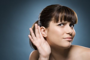 Woman putting hand to her ear