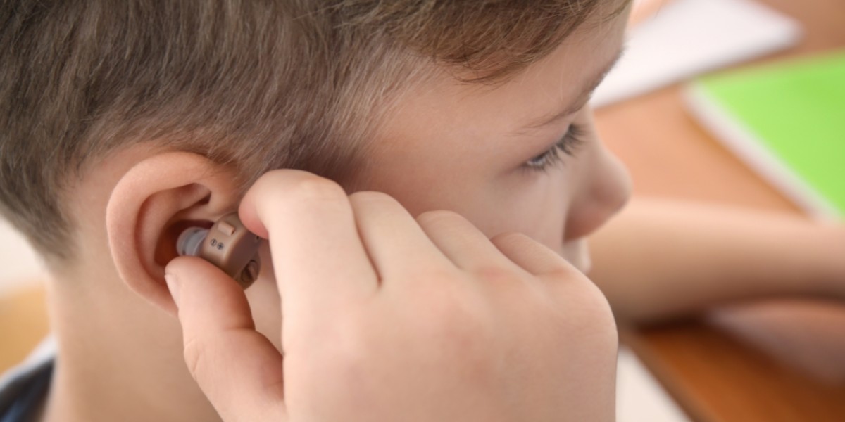 picture of a child putting in his hearing aids from platinum hearing aids in detroit