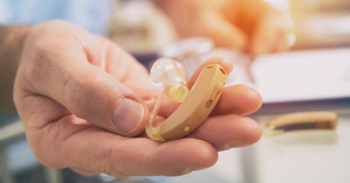 picture of person holding hearing aids offered by platinum hearing aids in detroit