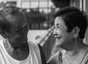 elderly Asian couple smiling at eachother