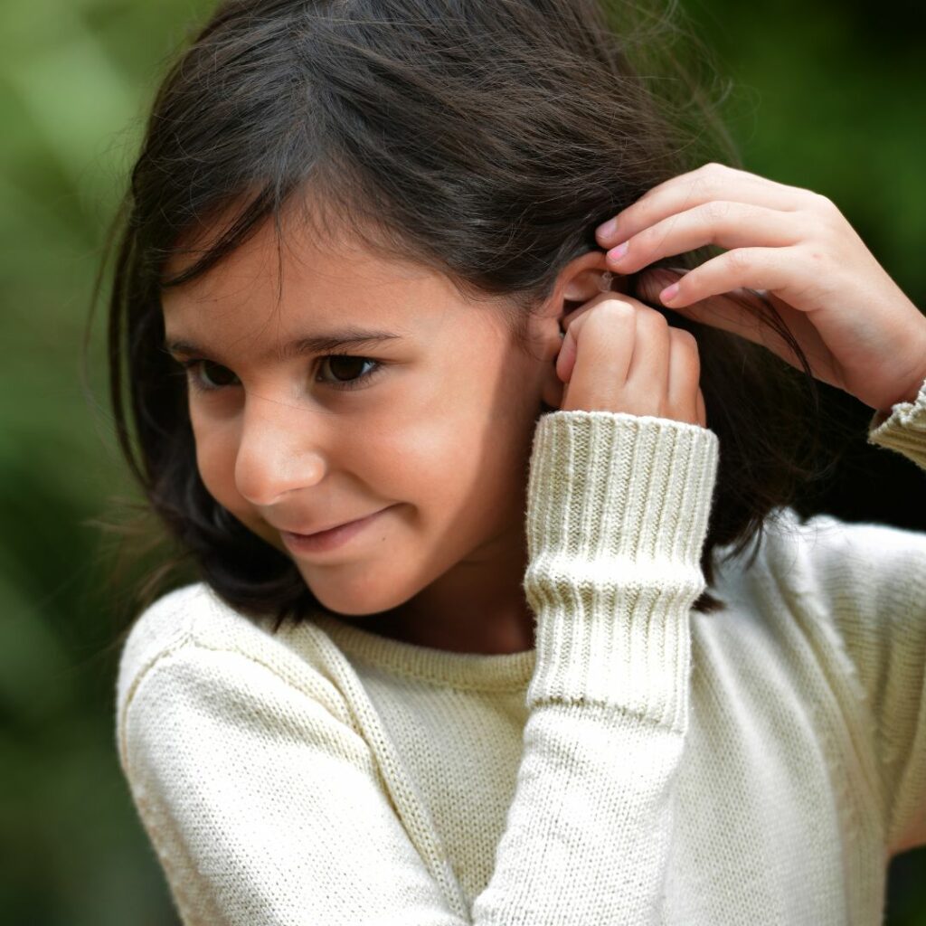 child putting in hearing aid